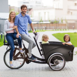 Young family having a ride with cargo bike